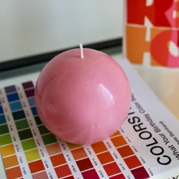 Spherical pillar candle in bubblegum pink color, available in medium and large sizes.