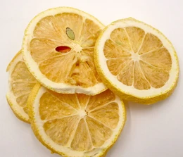  Freeze-dried lemon powder, a single dried fruit product. Bright yellow lemon slices with visible seeds and pulp. Packaged in a white container with a gold label.