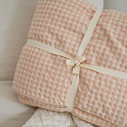  Soft, cozy peach-colored blanket with a checkered pattern, perfect for adding warmth and comfort to any bedroom.