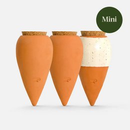 "Mini terracotta plant pots in the shape of carrots, with a speckled white glaze and cork lids. Ideal for small plants, herbs, or decorative accents."
