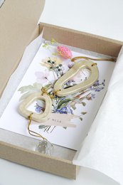 Ceramic wall hanger with round shapes and leaf-like design, available in neutral colors.