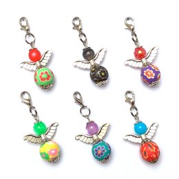 Set of 6 silver-colored guardian angel "Flora" keyrings with colorful enamel accents. Includes hummingbird, flower, and fruit-shaped charms.