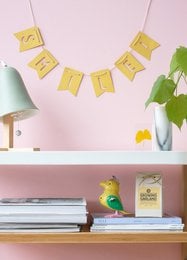 Colorful party bunting with a cheerful "Smile!" message, featuring a garland-style design in yellow and green tones.