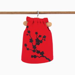 "Red dress with black floral pattern, suitable for a doll. Soft, plush material with a simple, elegant design."