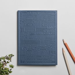 A green notebook with an embossed geometric pattern, available in various colors including blue, yellow, rust, green, concrete, and lavender.