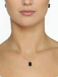 A dark, rectangular pendant necklace with a sleek, minimalist design. The pendant features a black gemstone or crystal set in a silver-toned metal frame, suspended from a delicate silver-toned chain.
