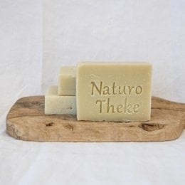 Vegan soap bars in natural beige color, made with natural ingredients. Rectangular shape with "Naturo Theke" text imprinted on the surface.