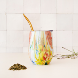 Colorful, patterned ceramic mug with a bombilla (straw) for drinking yerba mate tea.
