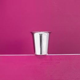 Tall, cylindrical glass mug with a shiny, metallic finish. Suitable for serving chai or other hot beverages.