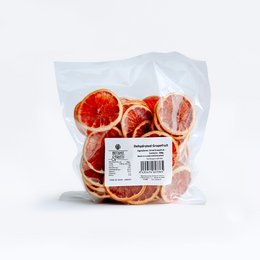 Dried grapefruit slices, vibrant orange-red in color, with a sweet and tangy flavor. Packaged in a clear plastic bag.