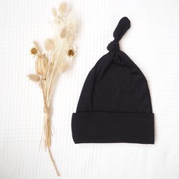 Black baby hat with a knot detail. Made of soft, comfortable material suitable for infants and toddlers.