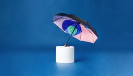 Compact umbrella with a colorful, abstract pattern design. Made of durable materials and includes a gift box.