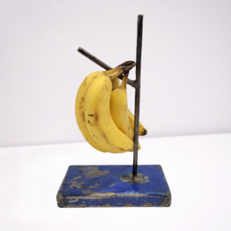 Upcycled banana holder made from old oil drums, available in blue, red, white, and yellow colors.