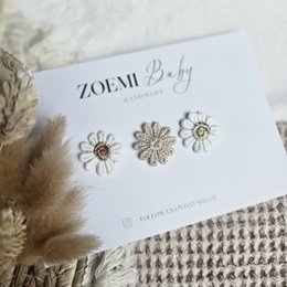 Cheerful mix of hair clips for kids, featuring a heart-shaped clip in a peach color and a floral clip in a neutral tone.