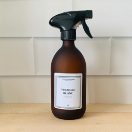  Glass bottle with white vinegar spray for all-purpose cleaning. Amber-colored glass bottle with black spray nozzle.