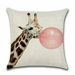 Cushion cover with a giraffe image, featuring a giraffe blowing a pink bubble gum bubble. The cushion cover is made of a light-colored fabric and has a playful, whimsical design.