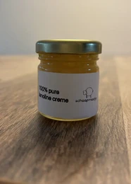 A small glass jar containing a thick, creamy yellow substance labeled "100% pure lanoline cream".