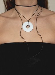  A round, white pendant necklace with adjustable black cord. Available in a variety of colors including beige, black, grey, pink, purple, chocolate, ocean green, white, khaki, and mint.