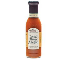 Curried mango BBQ sauce with a vibrant orange color and a blend of spices, perfect for grilling and adding flavor to your favorite dishes.