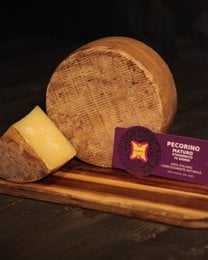 Aged pecorino cheese, hard texture, pale yellow color, round wheel shape, artisanal Italian sheep cheese, 75 days matured.