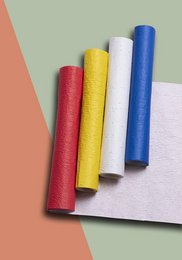 Colorful wrapping paper rolls in red, yellow, blue, and white. The wrapping paper has a jungle or nature-inspired pattern.