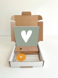 A small, blue gift box with a heart design. The box is made of cardboard and contains a candle.