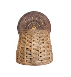 Natural Fibers Sconce wall, a woven wall light fixture with a decorative metal backplate featuring a sun design.