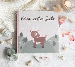 A baby's first-year book with a cute deer illustration on the cover, featuring a soft, cozy, and warm design.