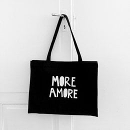 Black tote bag with white text "MORE AMORE" printed on it. The bag has two black handles and appears to be made of a durable, canvas-like material.