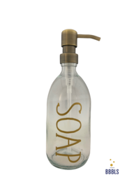 A transparent glass soap dispenser with a gold-colored pump and the word "SOAP" printed on the bottle in a premium style. The dispenser has a capacity of 500ml.