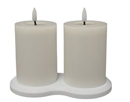 A pair of white, rechargeable LED candles on a white stand.