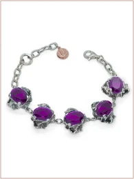  Oval-shaped purple gemstone cuff bracelet with silver-tone metal accents.
