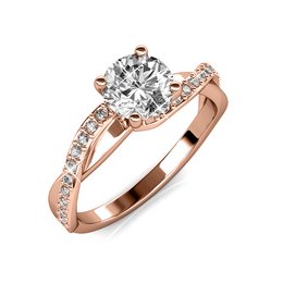 The Eleanor Ring is a rose gold and crystal engagement ring featuring a round brilliant cut diamond center stone surrounded by smaller accent diamonds. The ring has a classic and elegant design with a modern twist.