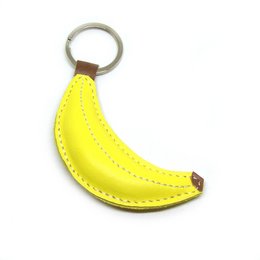 A bright yellow banana-shaped leather keychain with a metal ring.