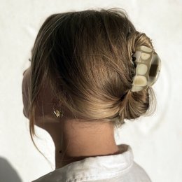 Beige checkerboard pattern hair clip with claw design for securing hair.