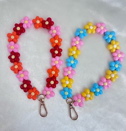  Colorful flower-shaped phone cord holders in various vibrant shades, including pink, yellow, orange, beige, fuchsia, and multicolor variants.