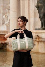  A light green canvas weekend bag with leather handles and trim, suitable for 2-3 day trips.