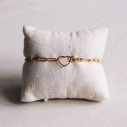 Gold-tone charm bracelet with open heart lock. Delicate chain links with a heart-shaped clasp.
