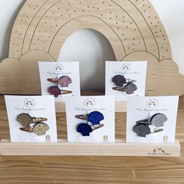 Double barrettes in various colors including gold, multicolor, silver, blue, and pink. Made of shells, these hair clips are stylish and versatile.