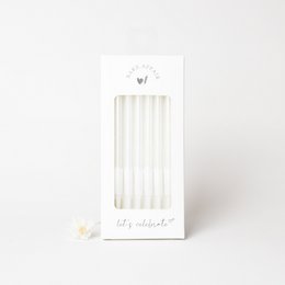 White birthday candles, tall and cylindrical in shape, made of wax material.