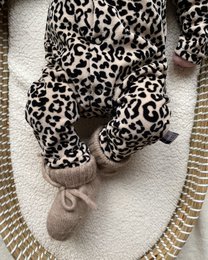 Soft, cozy merino wool bootie slippers in a natural leopard print pattern. Perfect for keeping baby's feet warm and comfortable.