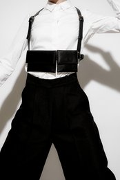 Black harness bag with adjustable straps and multiple pockets for storage.