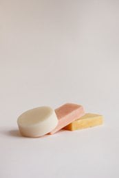 Solid soap bars in various colors and shapes, suitable for hotel use.
