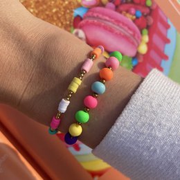 Colorful beaded bracelet with a variety of round, multi-colored beads in different sizes and shapes, including some with patterns. The bracelet has a casual, playful style.