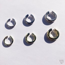 Ear cuff in silver and gold colors, available in sizes 3, 4, and 5. Unique curved design with a modern, minimalist style.
