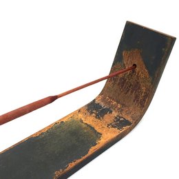 Long, rectangular incense holder made of rustic, distressed metal with a copper-colored handle.