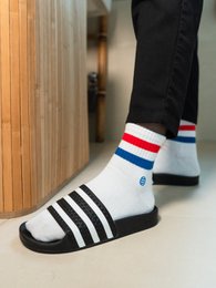 Short white socks with sporty stripes and logo, suitable for athletic activities.