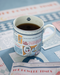 "White ceramic mug with dog paw print, newspaper print design, humorous 'Woof Street Journal' text, cylindrical shape"