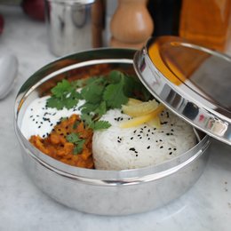 Silver stainless steel storage box with a round, stackable design. Suitable for storing and transporting lunch or snacks.