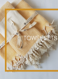 A set of soft, absorbent bath towels in a variety of colors including petrol, mustard, burgundy, olive green, grey, granite grey, black, beige, navy, pink, and forest green. The towels feature a textured diamond pattern design and come with matching hand towels.